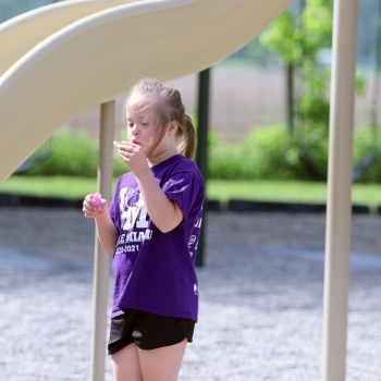 student outdoors blowing bubbles